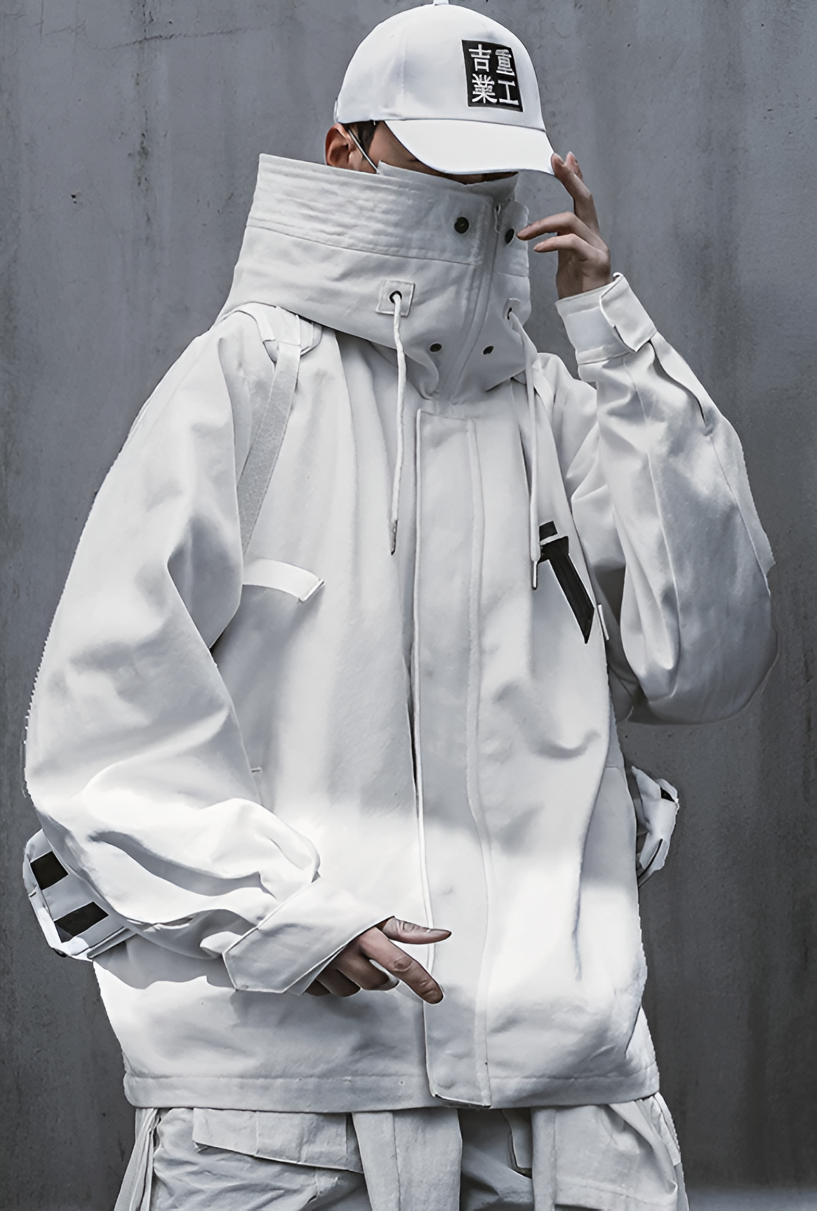 Veste ERI techwear blanche porter par un homme avec une casquette blanche